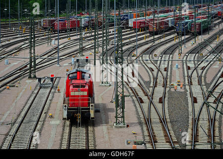 Locomotiva rossa, nel retro contenitori sulle piste, cantiere ferroviario Maschen, Seevetal, Bassa Sassonia, Germania Foto Stock