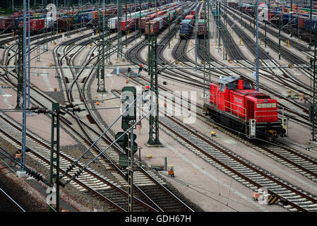 Locomotiva rossa, nel retro contenitori sulle piste, cantiere ferroviario Maschen, Seevetal, Bassa Sassonia, Germania Foto Stock