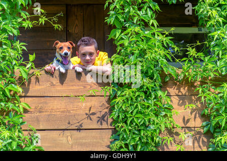 Ragazzo sorridente con il cane su treehouse. L'estate! Foto Stock