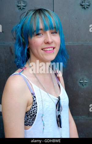 Una giovane bella donna sorridente con i suoi capelli tinti di blu pone per un ritratto a Southsea England Regno Unito Foto Stock