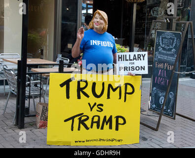 Bob Kunst, 74 di Miami Beach, Florida, un pioniere internazionale dei Diritti dei Gay e presidente di Shalom International, campagne indossa una maschera per la simulazione di ex Segretario di Stato statunitense Hillary Clinton vicino al dall'Arena Quicken Loans, sito del 2016 Convention Nazionale Repubblicana in Cleveland Ohio Sabato, 16 luglio 2016. Kunst è un ex sostenitore di Hillary Clinton e dal 2003 al 2008 è stato presidente di hillarynow.com, uno sforzo di progetto di Segretario Clinton per funzionare per il Presidente degli Stati Uniti. Credito: Ron Sachs/CNP (restrizione: NO New York o New Jersey quotidiani o giornali Foto Stock