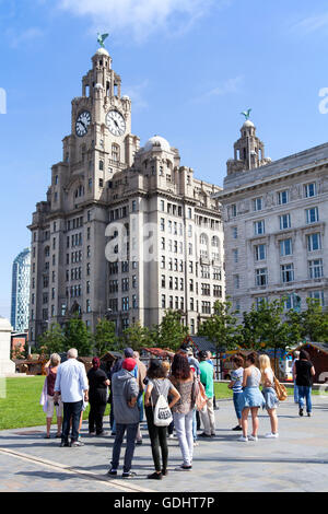 Liverpool, Merseyside Regno Unito.18 Luglio, 2016. Regno Unito Meteo. Una calda giornata di sole su Liverpool accoglie gli studenti stranieri e turisti provenienti dall'UE. Le visite guidate prendere loro lungo il percorso della città famosa storia con gite a 'Beatles Story' e fab four sculture. Contro il magnifico sfondo di 'le Tre Grazie' compresa la famosa "Liver Building', i visitatori sono assegnati a una guida per mostrare loro le attrazioni storiche della città ha da offrire. Credito: Cernan Elias/Alamy Live News Foto Stock