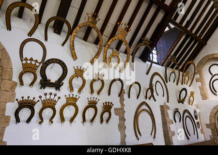 Interno della grande hall dove oltre 230 ferri di cavallo appesi alle pareti il castello di Oakham Rutland East Midlands UK Foto Stock