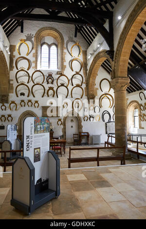 Interno della grande hall dove oltre 230 ferri di cavallo appesi alle pareti il castello di Oakham Rutland East Midlands UK Foto Stock