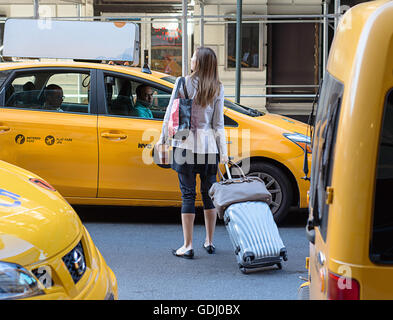 Una donna in cerca di un taxi il 4 di luglio weekend. Foto Stock