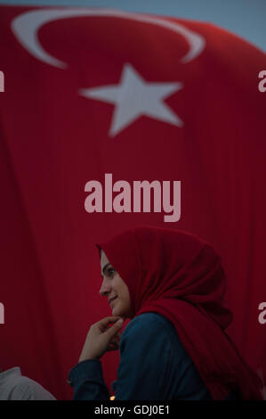 La donna musulmana che indossa velo rosso con bandiera turca Istanbul Turchia Foto Stock