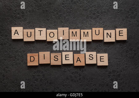 La parola malattia autoimmune formato con lettere in legno su sfondo scuro Foto Stock