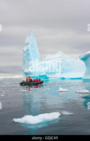 Zodiac guardandosi intorno iceberg con i passeggeri in Antartide. Foto Stock