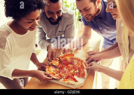 Happy business team di mangiare la pizza in ufficio Foto Stock