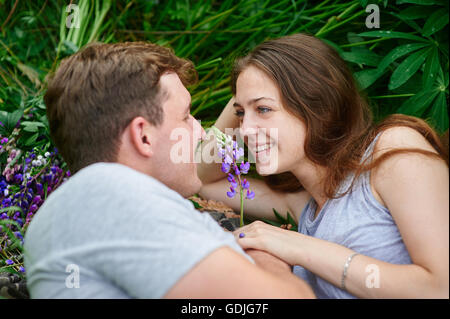 Matura in amore giacente in erba su un prato estivo Foto Stock