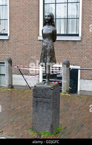 Una piccola scultura in bronzo di 'casa di Anne Frank' come in piedi di una piccola ragazza, Amsterdam, Olanda, Paesi Bassi. Foto Stock