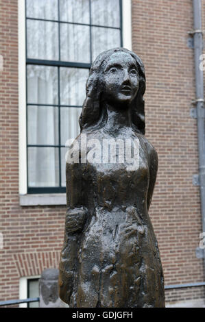 Una piccola scultura in bronzo di 'casa di Anne Frank' come in piedi di una piccola ragazza, Amsterdam, Olanda, Paesi Bassi. Foto Stock