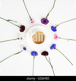 Tazza di caffè con il pattern da petali di fiori di campo su sfondo bianco. Vista aerea. Lay piatto. Foto Stock