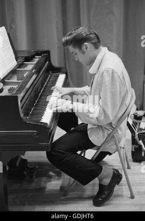 Elvis Presley trascorre qualche ora sul pianoforte in attesa per uno spettacolo di inizio alla University of Dayton Fieldhouse, 27 maggio, 1956. Foto Stock