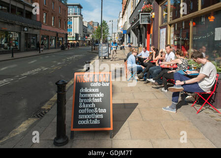 Per coloro che godono di un drink al di fuori di giorno e di notte cafe a Oldham Street nel quartiere settentrionale area di Manchester. Foto Stock
