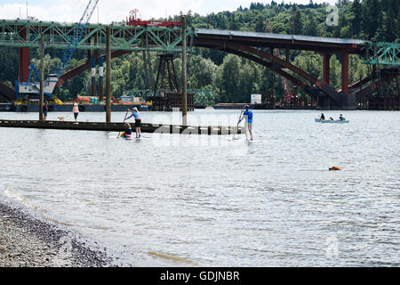 Stand Up Paddle boarders sul fiume Willamette davanti al ponte Sellwood, Portland Oregon Foto Stock