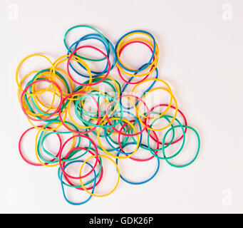Pila di nastri di gomma di diversi colori su bianco Foto Stock