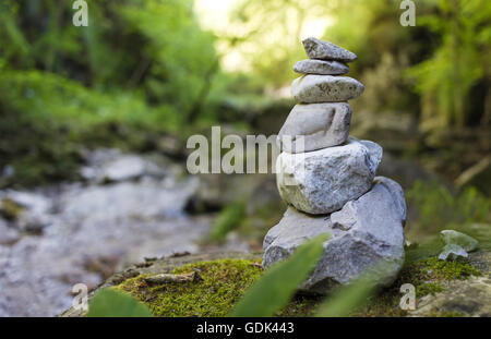 Pila di pietre ghiaia da un flusso in una foresta Foto Stock