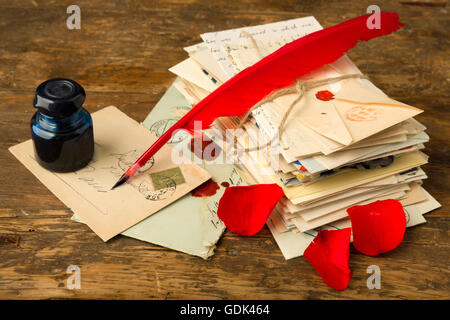 Red Quill penna ed inchiostro ben disteso su un vecchio tavolo con lettere di nostalgico Foto Stock