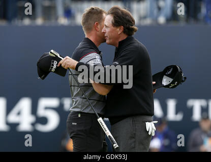 Svedese Henrik Stenson (sinistra) abbracci USA di Phil Mickelson come egli celebra vincendo il campionato aperto durante il giorno quattro del Campionato Open 2016 al Royal Troon Golf Club, South Ayrshire. Foto Stock