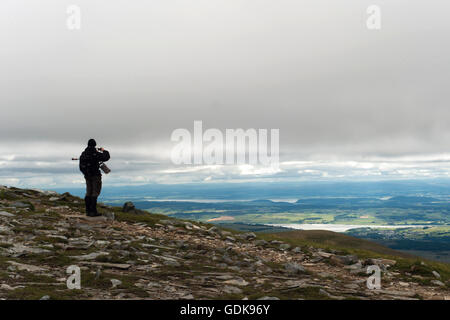 Uomo che guarda alla vista di Dingwall, cromarty firth da ben wyvis Foto Stock