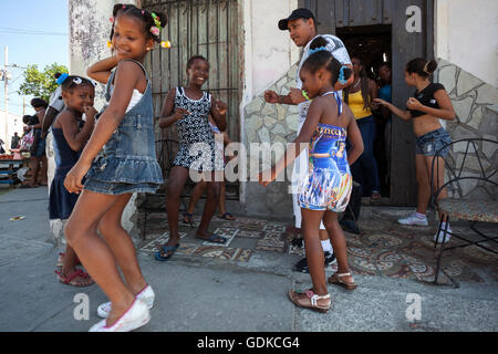 Bambini locali ballare con il loro insegnante di danza davanti a una scuola di danza per strada e Santiago de Cuba Provincia Foto Stock