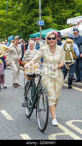 Woodhall Spa 1940 Festival - donna nel tradizionale 1940s condire con la bicicletta Foto Stock