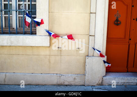 La Francia. Ad Arles. Tricolore francese bandiere contro una parete Foto Stock