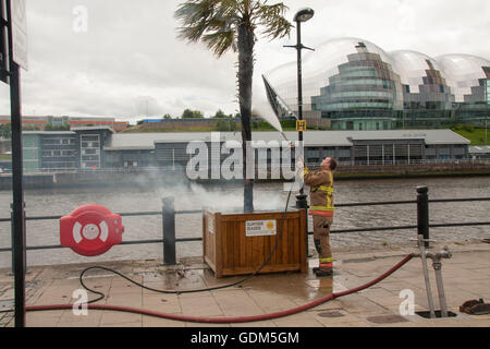 Il Quayside, Newcastle upon Tyne, Regno Unito. 18 Luglio, 2016. I vigili del fuoco di affrontare la masterizzazione di Palm tree alla banchina del porto di mare. David Dixon / Alamy Live News Foto Stock