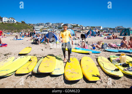 Polzeath, Cornwall, Regno Unito Il 18 luglio 2016. I surfisti e le famiglie accorrono alla spiaggia su una calda e soleggiata giornata in Cornovaglia. Si trova sulla North Cornwall dalla costa atlantica, Polzeath è un luogo molto popolare per i surfisti. Credito: Mark Richardson/Alamy Live News Foto Stock