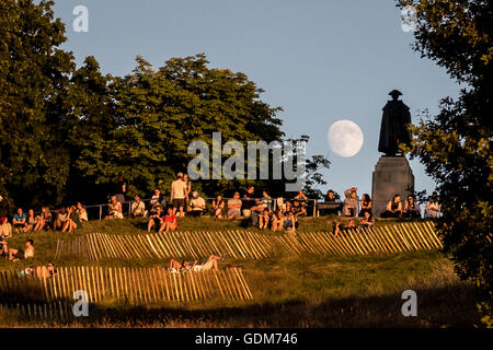 Londra, Regno Unito. 18 Luglio, 2016. La luna sorge su Greenwich Park accanto al Generale James Wolfe statua. Il parco di Greenwich, a sud-est di Londra Credito: Guy Corbishley/Alamy Live News Foto Stock