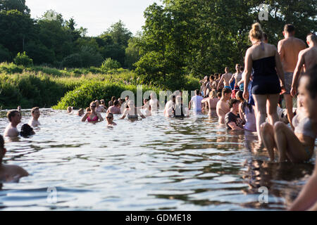 Molte persone attraversando a piedi e nuotare nel fiume Avon. Centinaia accorrono per Warleigh Weir a 3 miglia da bagno, sulla giornata di caldo Foto Stock