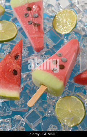 Anguria, frutta ghiaccioli e fettine di lime a cubetti di ghiaccio Foto Stock
