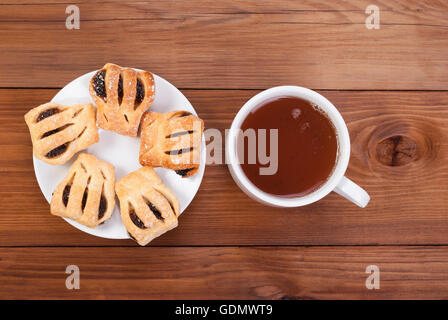 Bollitore per tè e biscotti dolci su di un tavolo di legno. Foto Stock