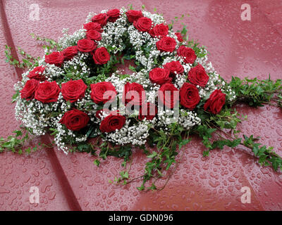 A forma di cuore bouquet floreali su una vettura sotto la pioggia, anniversario di matrimonio Foto Stock