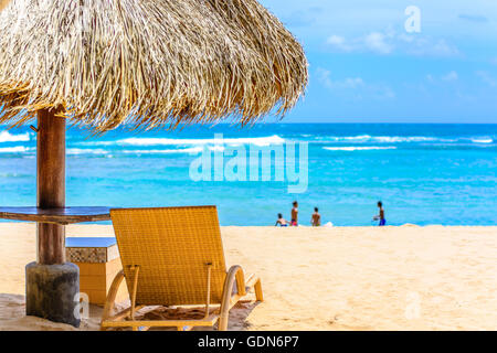 Una bella scena di spiaggia con ombrellone e sedie in un paradiso tropicale di Bali Foto Stock