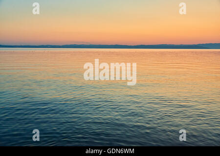 Tramonto sul lago di Garda, vista dalla penisola di Sirmione che divide la parte inferiore del Lago di Garda. Si tratta di un famoso luogo di vacanza. Foto Stock