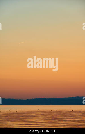 Tramonto sul lago di Garda, vista dalla penisola di Sirmione che divide la parte inferiore del Lago di Garda. Si tratta di un famoso luogo di vacanza. Foto Stock