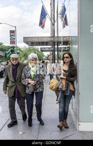 Elegantemente informale elder giovane guarda askance come fortyish donna in costosi faux jeans scoloriti appoggia contro il negozio azienda gelato Foto Stock