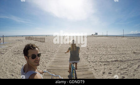 L'uomo prendendo selfie escursioni in bicicletta sulla passeggiata a mare di legno della Spiaggia Venice, California, Stati Uniti d'America Foto Stock