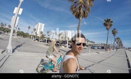 L'uomo prendendo selfie escursioni in bicicletta a Venice Beach, California, Stati Uniti d'America Foto Stock