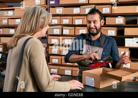 Cliente femmina acquistare scarpe in un tradizionale negozio di scarpe Foto Stock