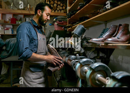 Cobbler maschio nella scarpa tradizionale Officina riparazione di boot Foto Stock