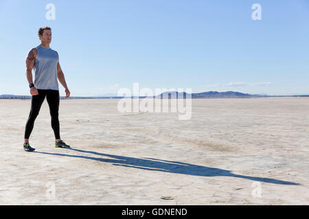 Uomo di formazione, guardando fuori dal dry lake bed, El Mirage, CALIFORNIA, STATI UNITI D'AMERICA Foto Stock