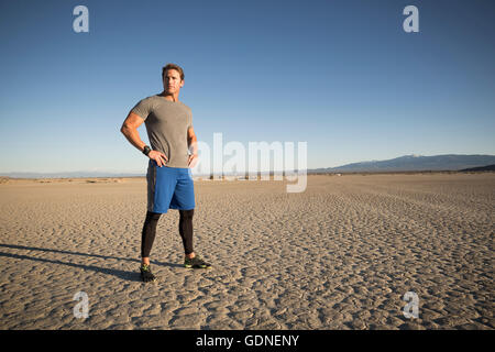 Uomo di formazione, guardando fuori dal dry lake bed, El Mirage, CALIFORNIA, STATI UNITI D'AMERICA Foto Stock