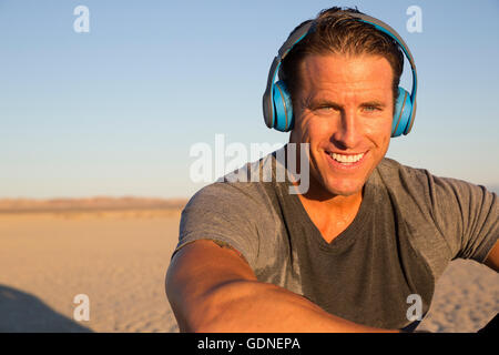 Uomo di formazione, ascolto di cuffie sul lago secco letto, El Mirage, CALIFORNIA, STATI UNITI D'AMERICA Foto Stock