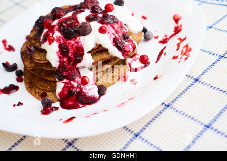 Un delizioso piatto con pancake e marmellata, con bacche sulla parte superiore Foto Stock
