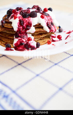 Un piatto pieno di frittelle con marmellata sulla parte superiore e yogurt, spazio per il testo Foto Stock