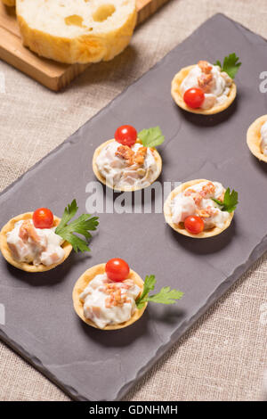 Crostini, antipasto con crema insalata di pollo servito su una piastra di ardesia Foto Stock