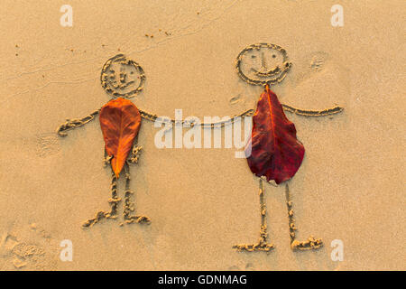 Paio di persone figure disegnate a mano sulla spiaggia di sabbia. Foto Stock